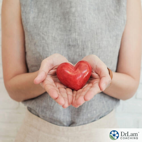 An image of a woman holding a heart out with both hands
