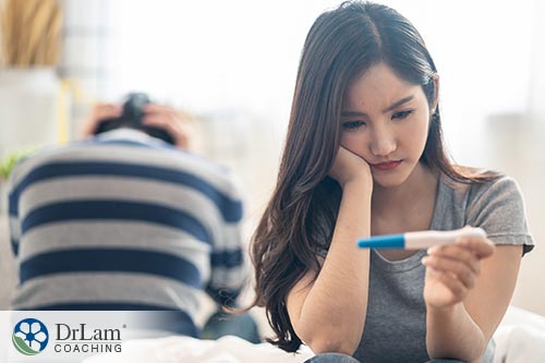 An image of a young woman staring at a pregnancy test