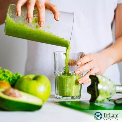A person pouring green smoothie into a glass