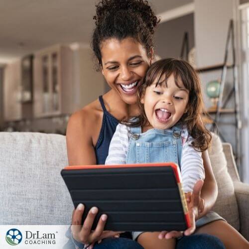 An image of a mother and daughter laughing while looking at an ipad