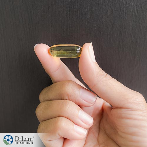 An image of a hand holding an evening primrose oil capsule