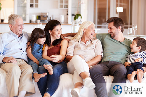 An image of a family group siting on a couch laughing together