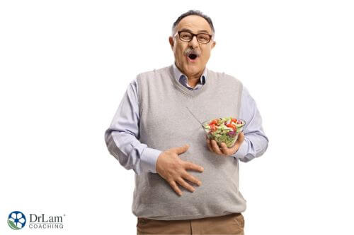An image of a man holding his stomach and a salad