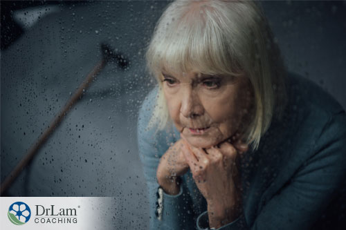 Image of an older woman depressed looking out a rainy window