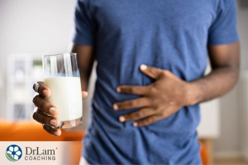 An image of a man holding a glass of milk and his stomach