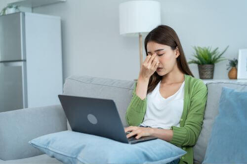 An image of a faituged woman with her laptop