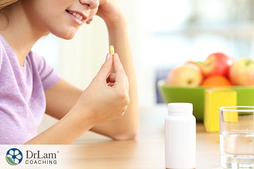 An image of a woman about to take a tablet of vitamin C
