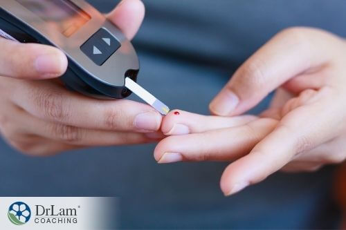 An image of a glucose meter and a hand with a pricked finger