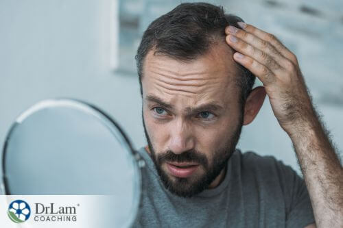 An image of a man looking at his receeding hair line in the mirror