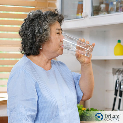 An image of a older woman drinking a glass of water