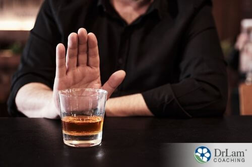 An image of someone saying no to a glass of alcohol