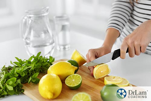 Woman slicing lemons to prepare for infused water herbs