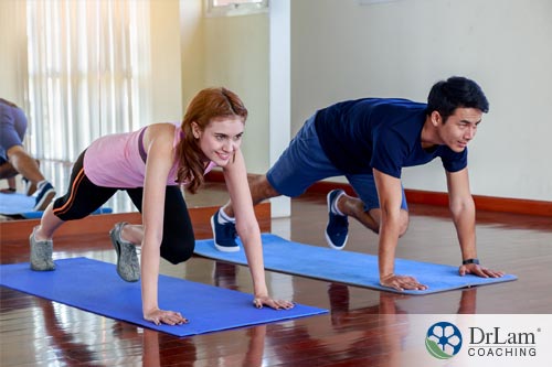 An image of two people, man and woman, doing mountain climbers a high intensity interval training pose