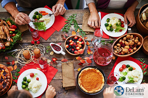 An image of four people with plates eating at a holiday table