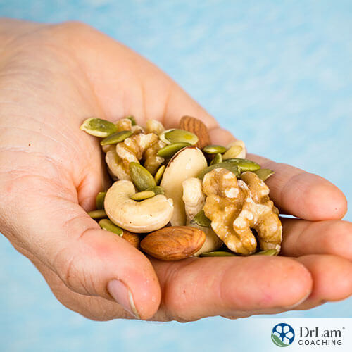 An image of a hand holding healthy nuts and seeds