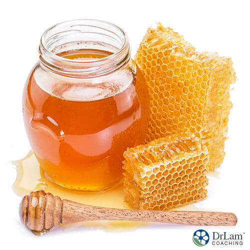 An image of honeycombs next to a jar full of honey