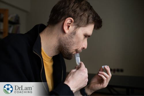 An image of a man spitting into a tube for a saliva test