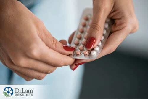 An image of a woman taking birth control pills out of the packet