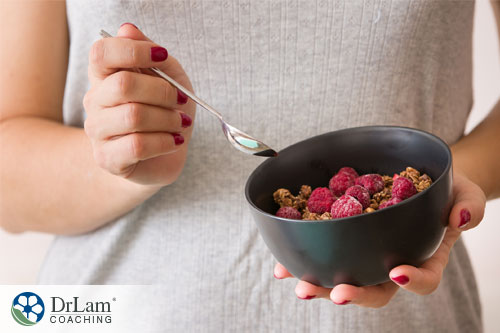 A woman with a bowl of frozen berries and granola