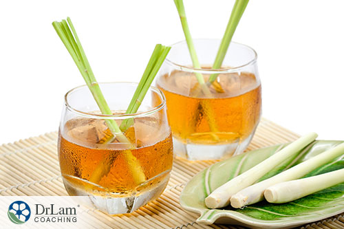 An image of two glasses of iced lemongrass tea with stocks of fresh lemongrass