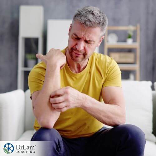 An image of a man scratching his hand