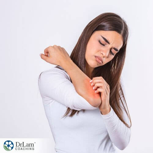 An image of a woman itching her contact dermatitis