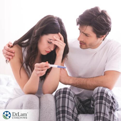 An image of a couple comforting each other while holding a pregnancy test