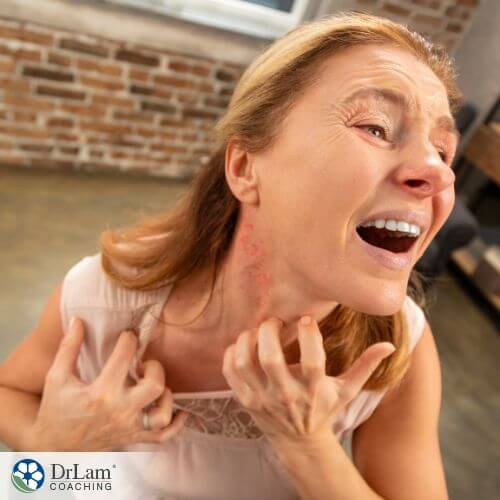 An image of a woman itching at the hives on her neck