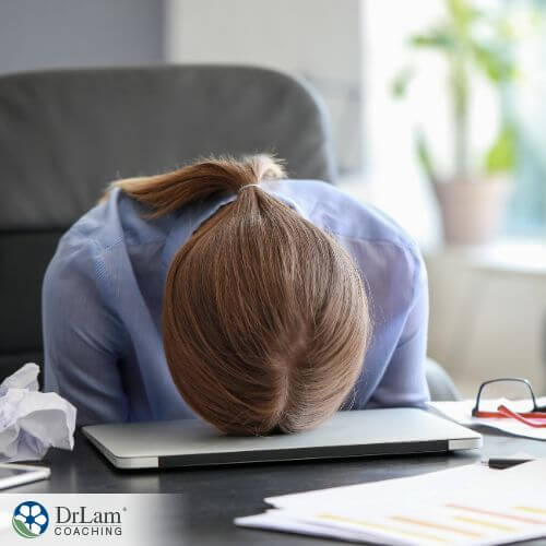 An image of a woman laying face down on her laptop