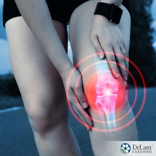 An image of someone holding their red, inflamed knee