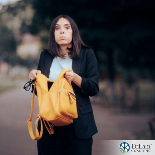 An image of a woman holding her purse and looking confused