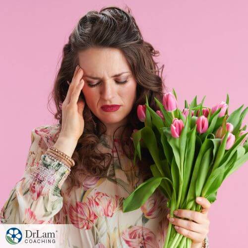 An image of a woman holding a bunch of tulips and her forehead