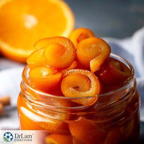 An image of a jar with candied orange peels inside