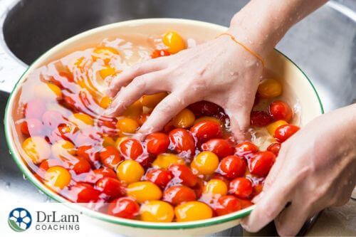 An image of someone washing yellow and red tomatoes in a bowl