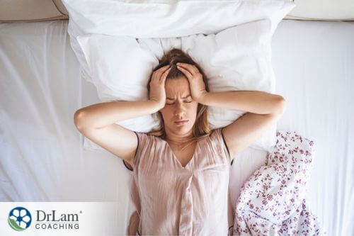 An image of a woman in bed trying to sleep
