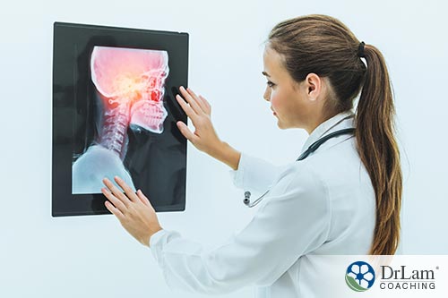 An image of a doctor looking at an x-ray of someone suffering from neck pain