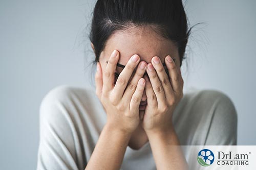 An image of a stressed out woman holding her face in her hands