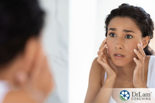 An image of a woman looking at her face in a mirror