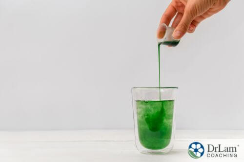 An image of liquid chlorophyll being poured into a glass of water