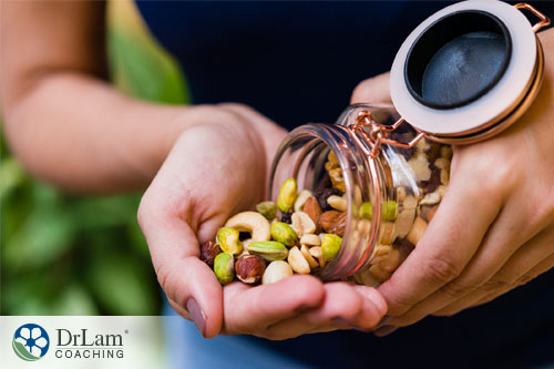 An image of a woman holding a jar of nuts
