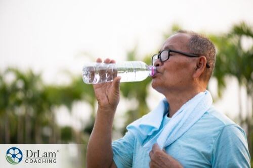An image of a man drinking water from a water bottle