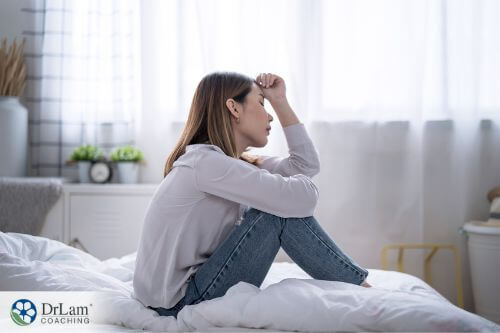 An image of a woman sitting on her bed