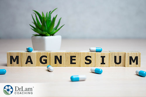 An image of wood blocks spelling out magnesium with blue and white capsules around it