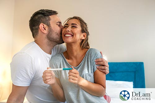 An image of a happy couple holding a pregnancy test
