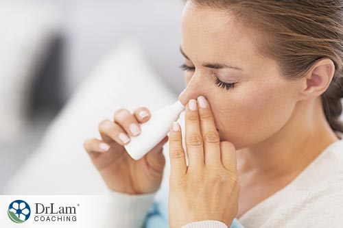 An image of a woman using a nasal spray
