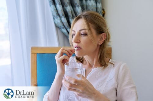 An image of a woman taking a pill
