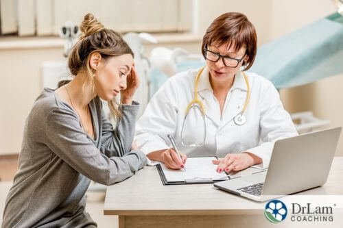 An image of a woman with a migraine talking to a doctor