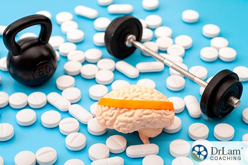 An image of pills, a toy brain, and small workout weights