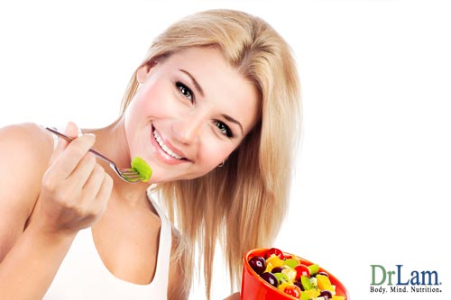 A young woman looking happy and holding a bowl of fruits. Comprehensive strategies including diet designed for healing adrenal fatigue can help your dry skin among other symptoms.