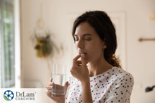 An image of a woman taking a supplement